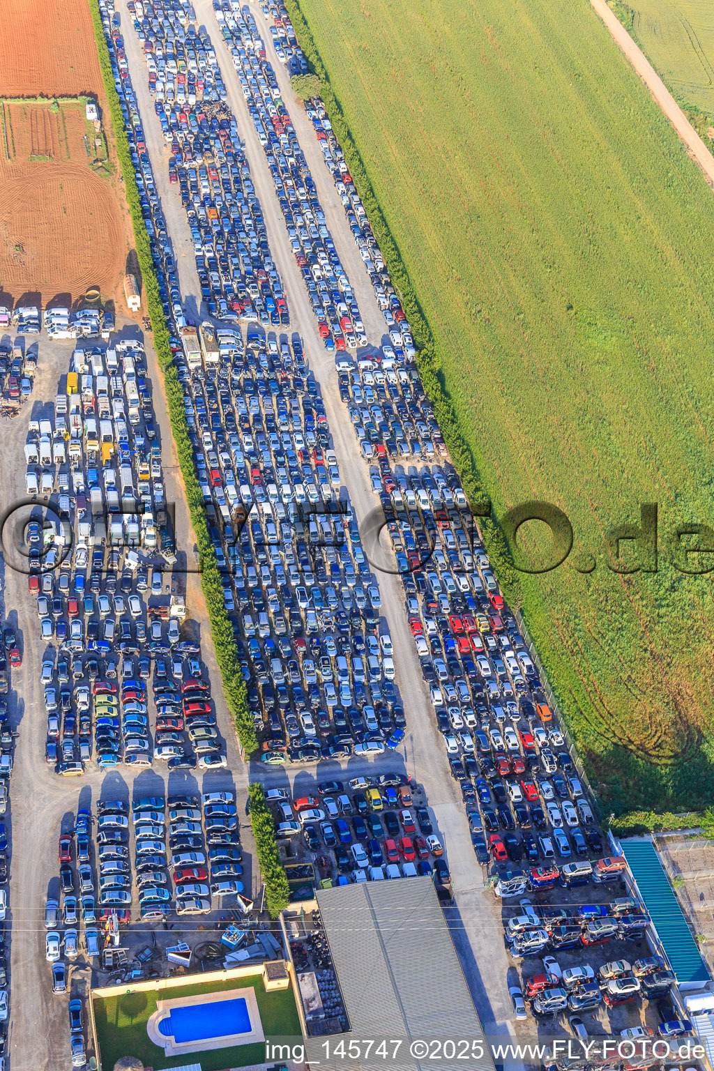 Oblique view of Rows of stacked old vehicles at the Desguace Siglo 21 scrapyard in Dos Hermanas in the state Seville, Spain