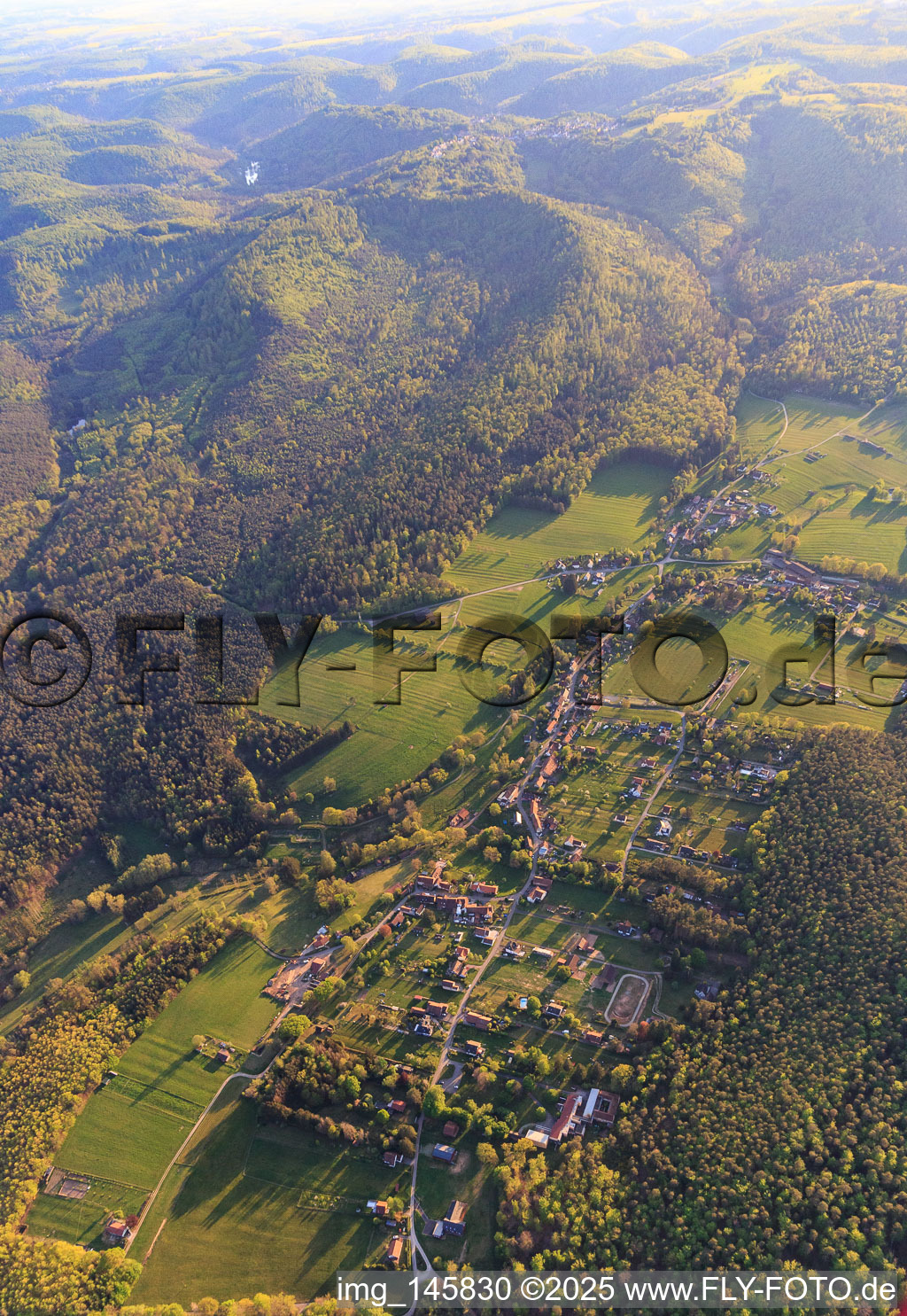 Village view in a forest clearing in the Northern Vosges from the northeast in Erckartswiller in the state Bas-Rhin, France
