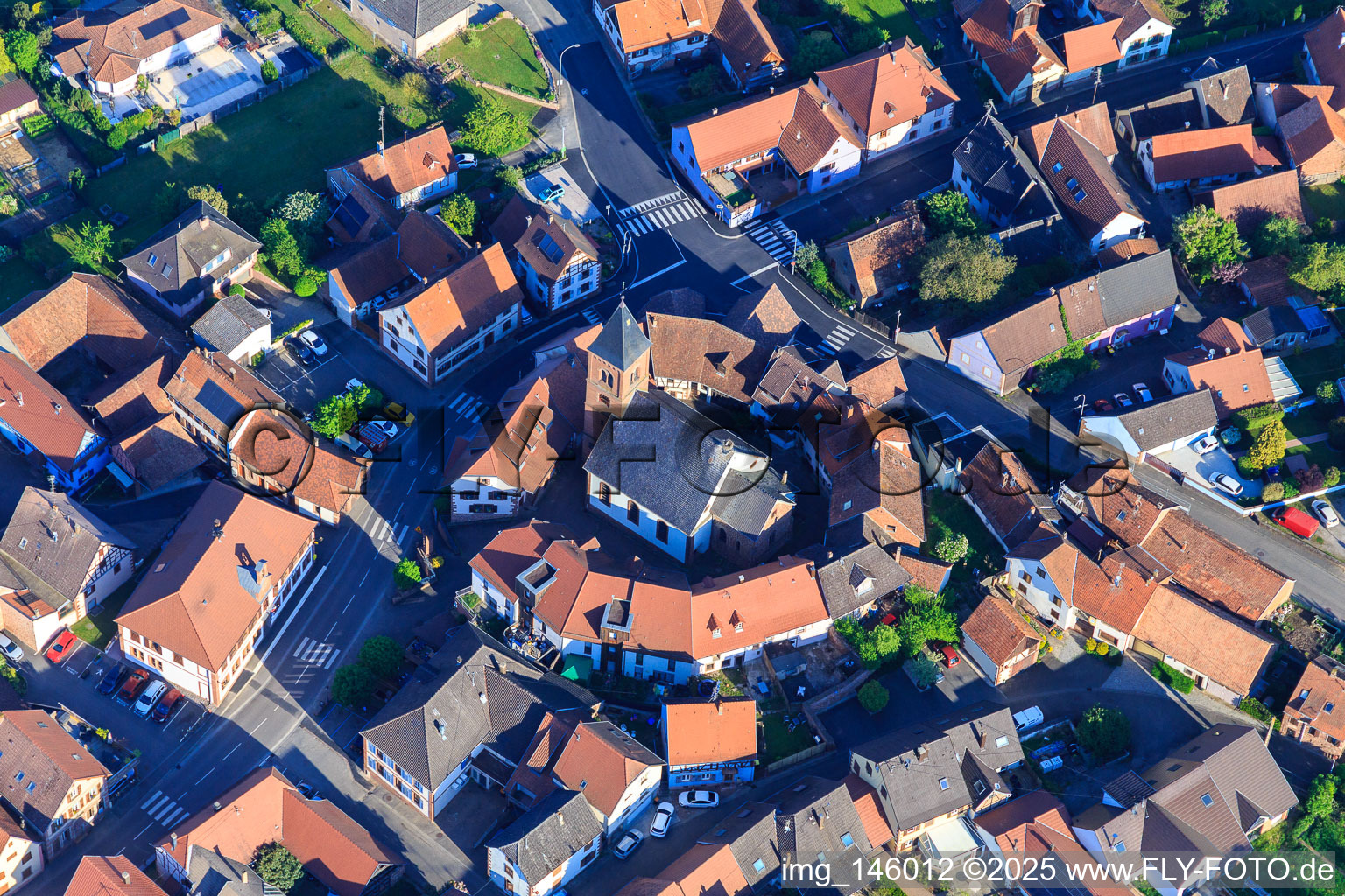 Aerial photograpy of Eglise protestante luthérienne as a fortified church surrounded by a circle of houses in Dossenheim-sur-Zinsel in the state Bas-Rhin, France