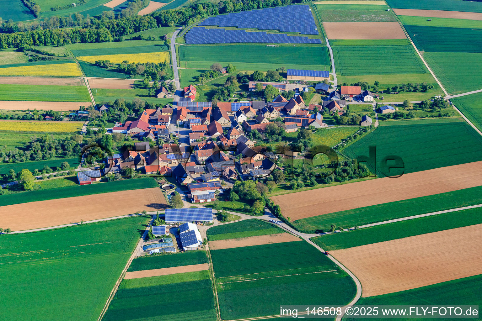 Village overview in the morning from the south with PV field in the district Buch in Bieberehren in the state Bavaria, Germany