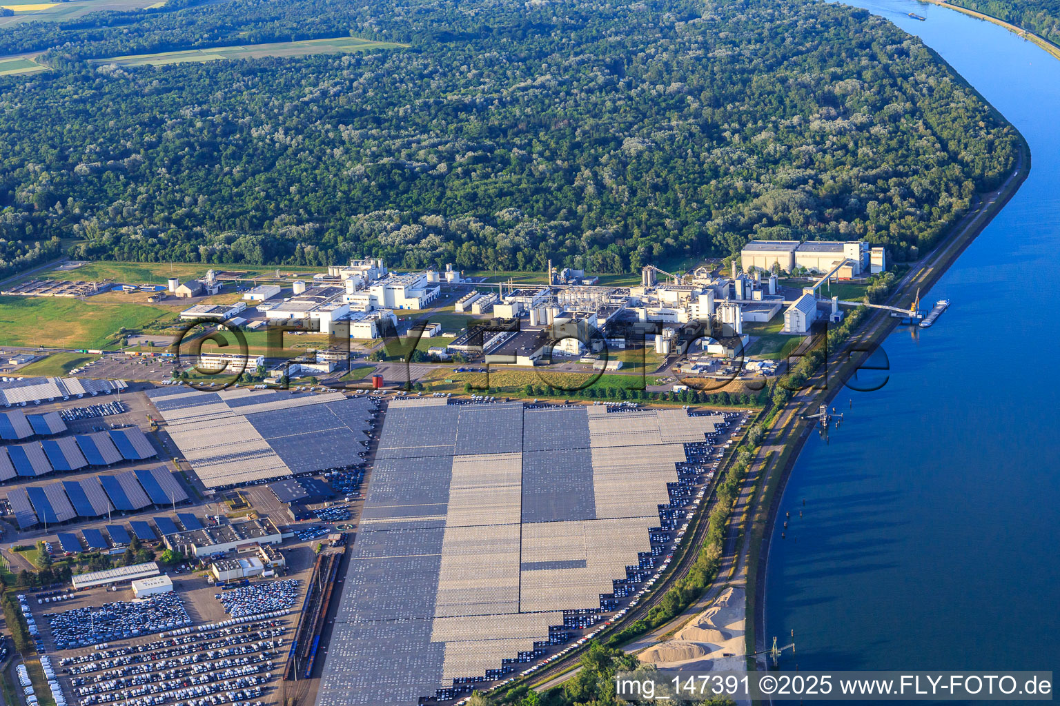 Aerial view of Industrial and Port Zone with industrial facilities on the Rhine belonging to Jungbunzlauer SA and TEREOS Starch & Sweeteners Europe in front of the CEVA Logistics car warehouse in Marckolsheim in the state Bas-Rhin, France