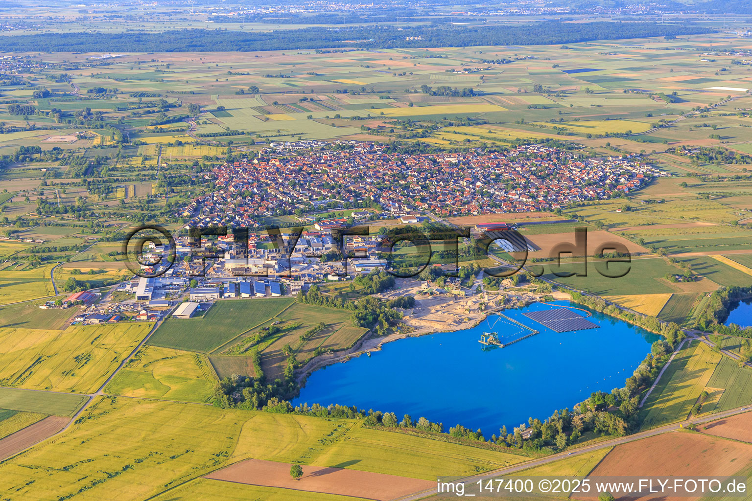 View of the town from the southwest with the Wyhl gravel pit and the floating PV system of Hermann Uhl KG - Wyhl-Ort plant in Wyhl am Kaiserstuhl in the state Baden-Wuerttemberg, Germany