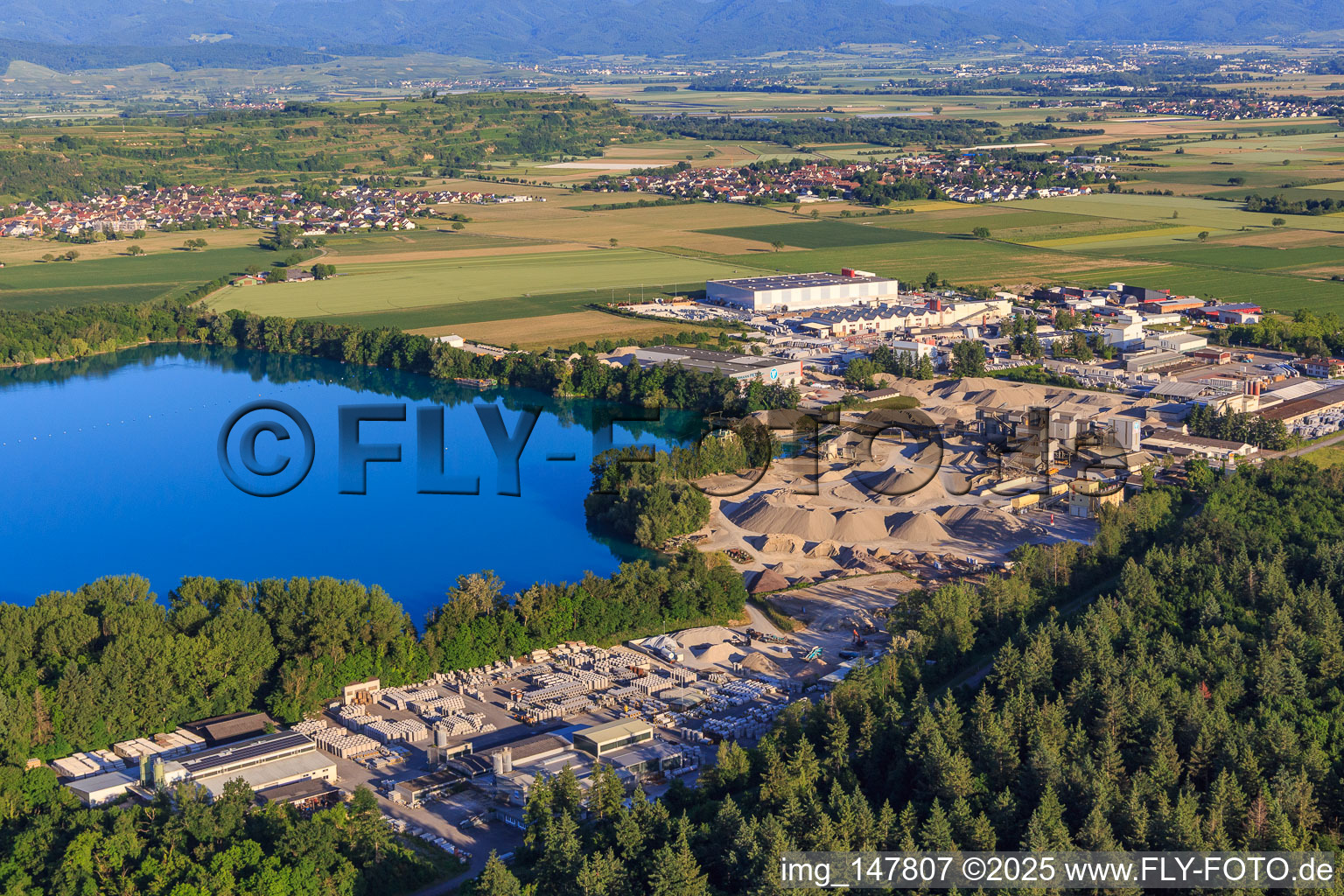 Aerial view of Rimsinger Baggersee / Niederrimsingen gravel pit with Betonwerk Müller GmbH & Co. KG, P & S-Beton GmbH & Co. KG and H+H Kalksandstein GmbH in the district Oberrimsingen in Breisach am Rhein in the state Baden-Wuerttemberg, Germany