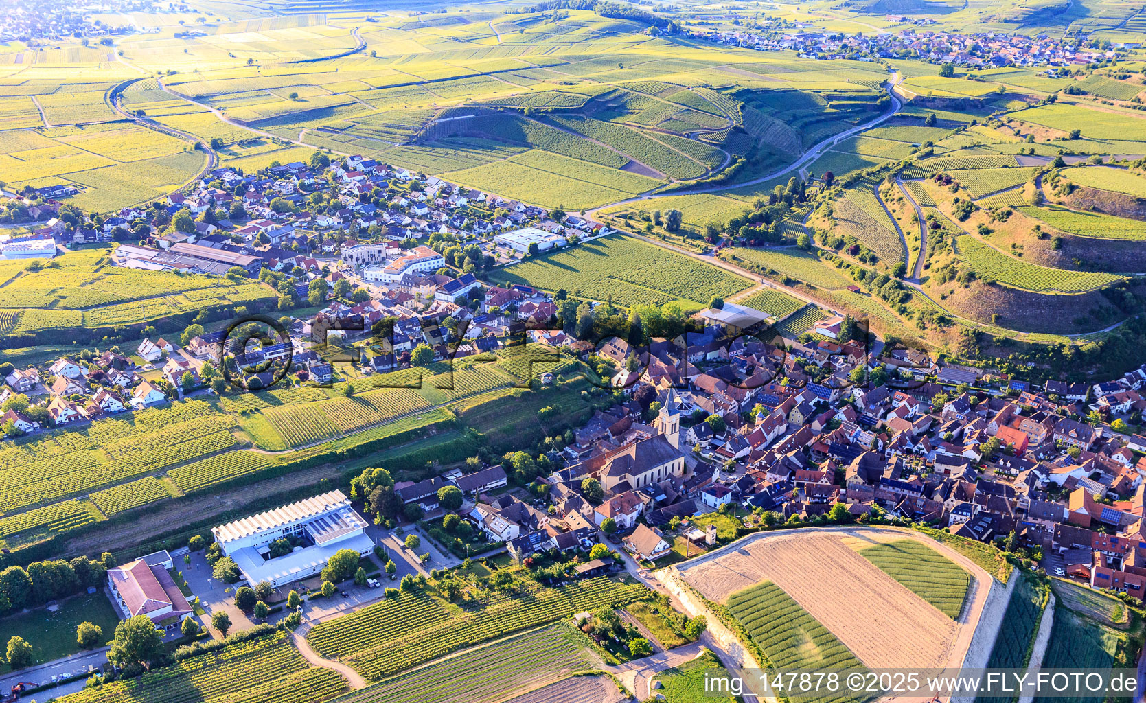 Eisentalstraße with St. John the Baptist Church and Wilhelm Hildenbrand School in the district Oberrotweil in Vogtsburg im Kaiserstuhl in the state Baden-Wuerttemberg, Germany