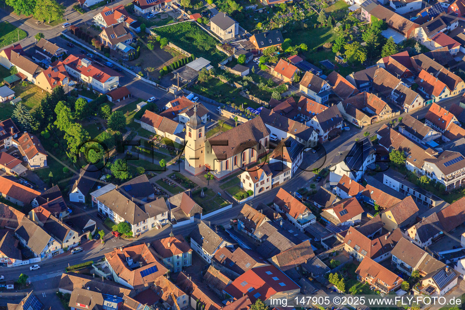 Village street with the church of Saint Cosmas and Damian in the district Jechtingen in Sasbach am Kaiserstuhl in the state Baden-Wuerttemberg, Germany