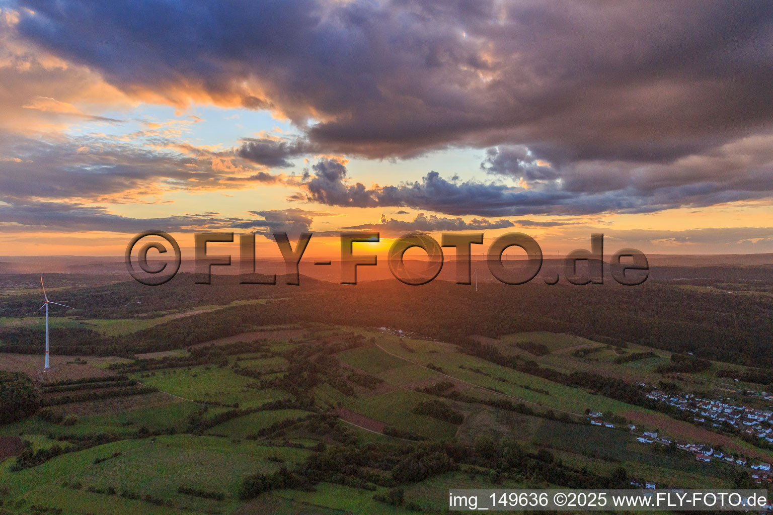 Sunset between telecommunications tower and wind turbine in the district Hüttersdorf in Schmelz in the state Saarland, Germany