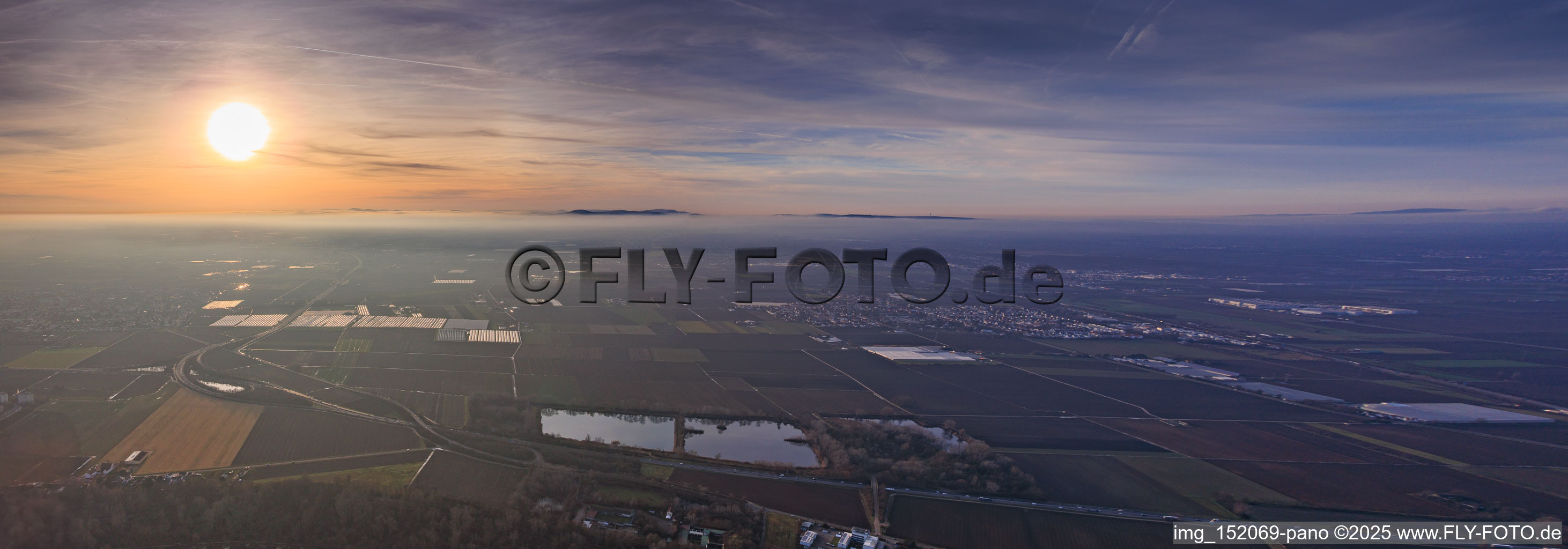 Sunset in the mist beyond the B9 highway above the Scheller Weiher pond, polytunnels belonging to P.+H. Fehmel Gemüsebau - FeSa Obst- & Gemüsehandels GmbH. in Mutterstadt in the state Rhineland-Palatinate, Germany