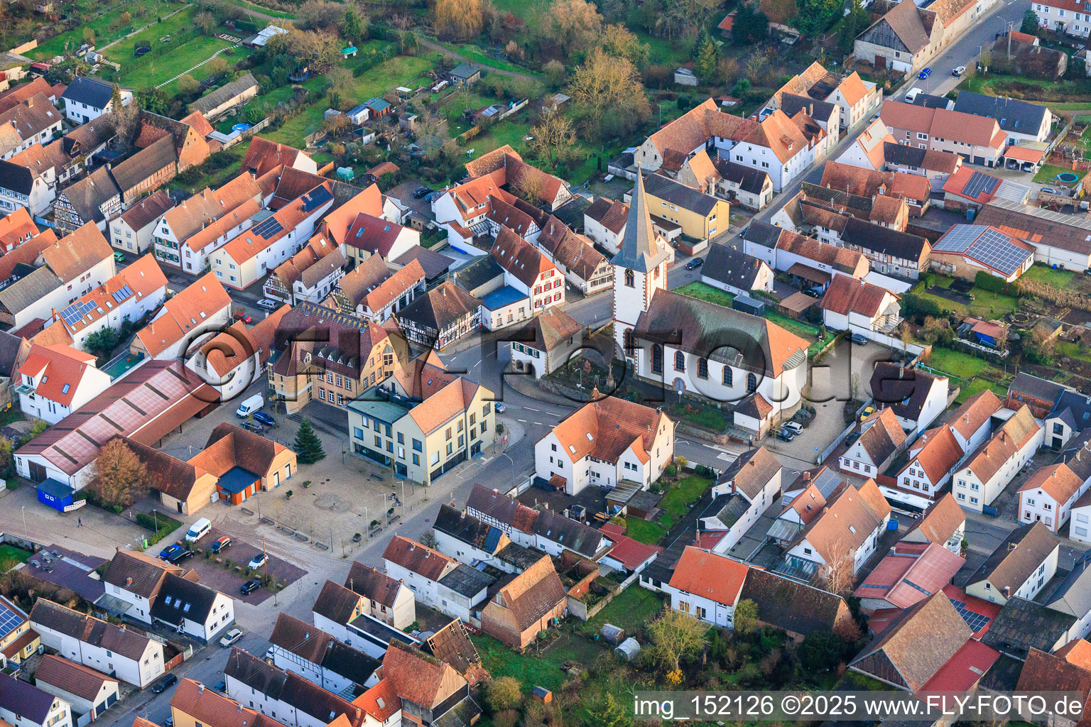 Village square with community center and VR Bank Südpfalz eG branch Ottersheim, as well as church in Ottersheim bei Landau in the state Rhineland-Palatinate, Germany