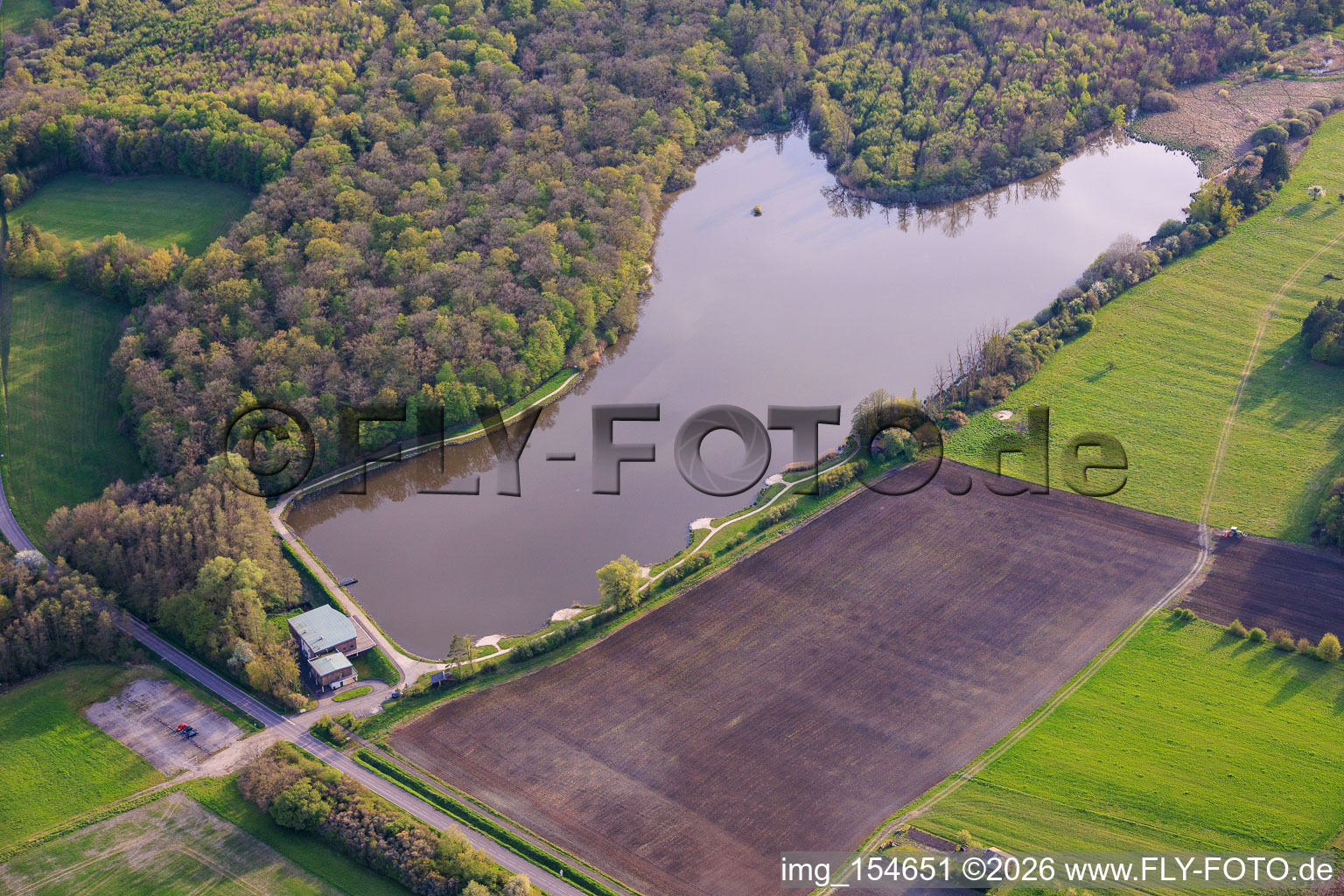 Fish pond Étang de Metzing and Salle Polyvalente L'Ecrin de Metzing at the edge of the forest in Metzing in the state Moselle, France