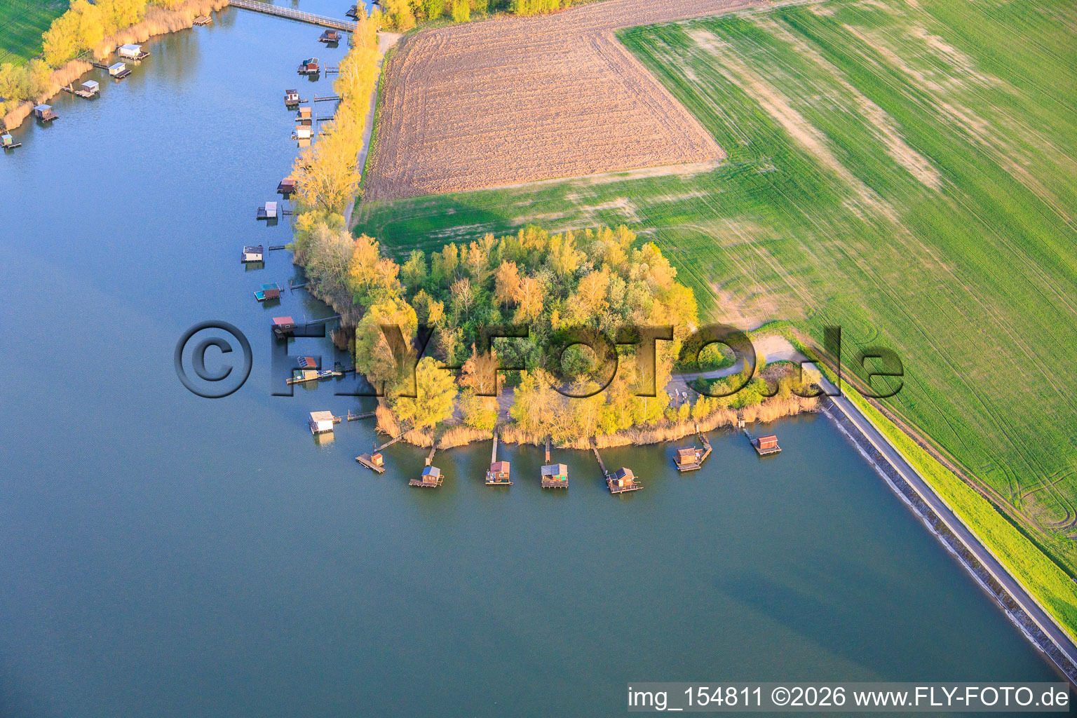 Boardwalks with fishing huts line the shore of Lake Etang du Welschhof. in Puttelange-aux-Lacs in the state Moselle, France