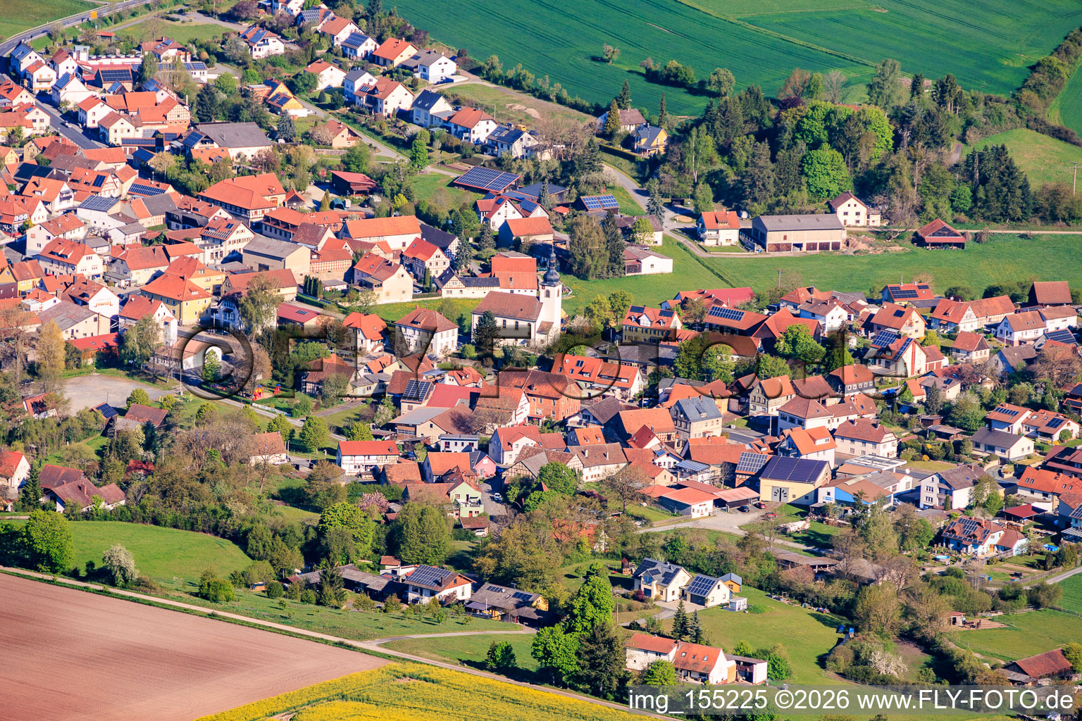 Village view from the southeast with the Evangelical Lutheran Church of St. Peter and the town hall. in Ermershausen in the state Bavaria, Germany