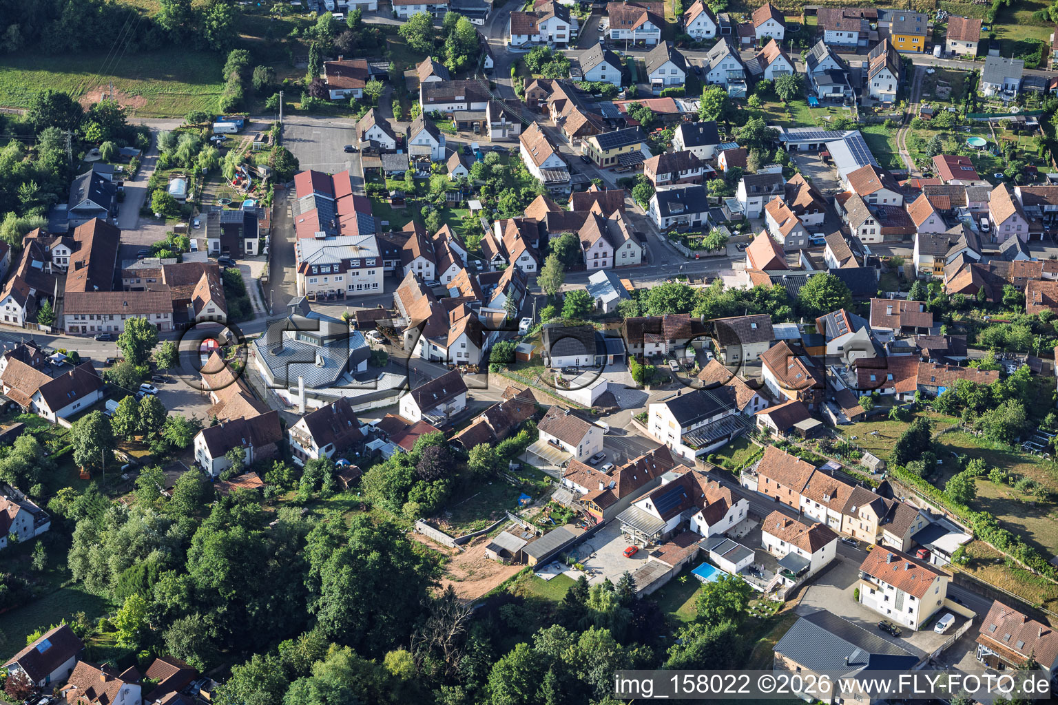 Modern church building of St. Sebastian and country inn Zur Linde in the village center in Silz in the state Rhineland-Palatinate, Germany