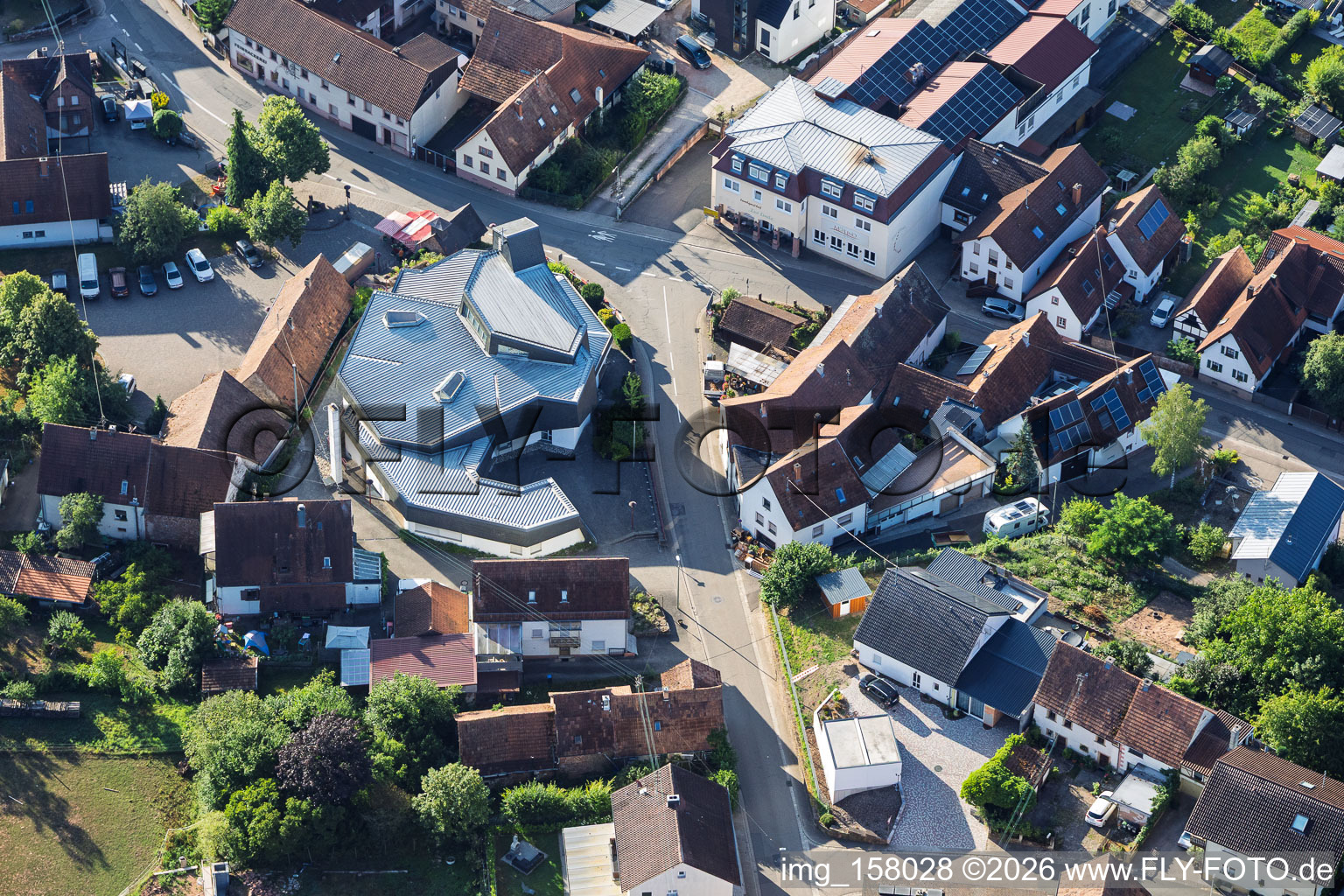Modern church building of St. Sebastian and country inn Zur Linde in the village center in Silz in the state Rhineland-Palatinate, Germany