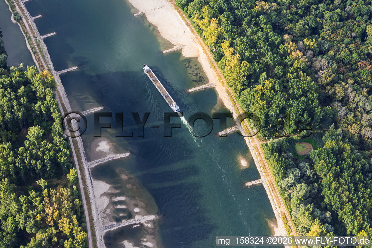 Empty cargo ship at low water on the Rhine between Hördter Rheinaue and Dettenheim in Hördt in the state Rhineland-Palatinate, Germany