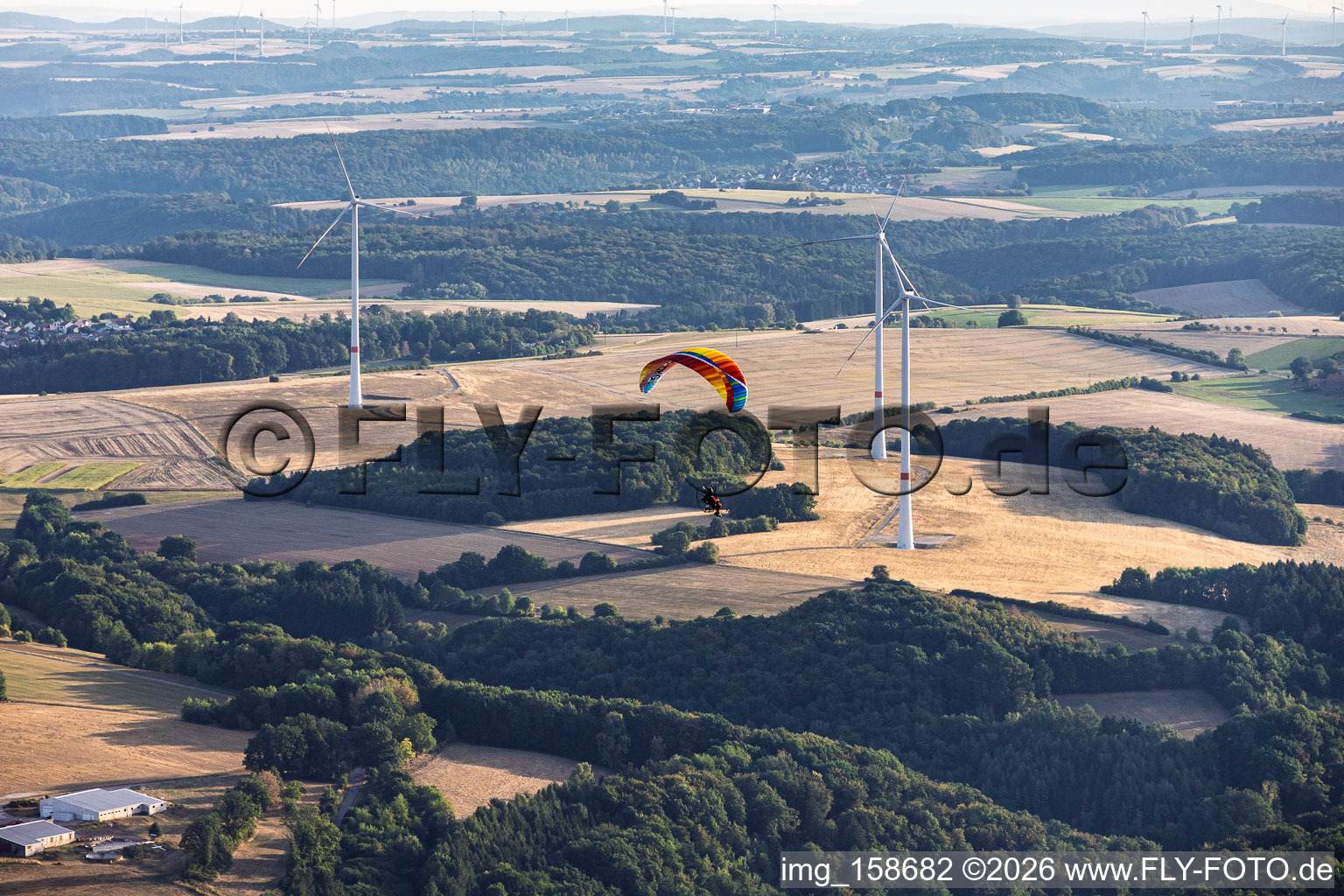Paraglider in front of the wind farm at Einöderwiesenhof in Riedelberg in the state Rhineland-Palatinate, Germany