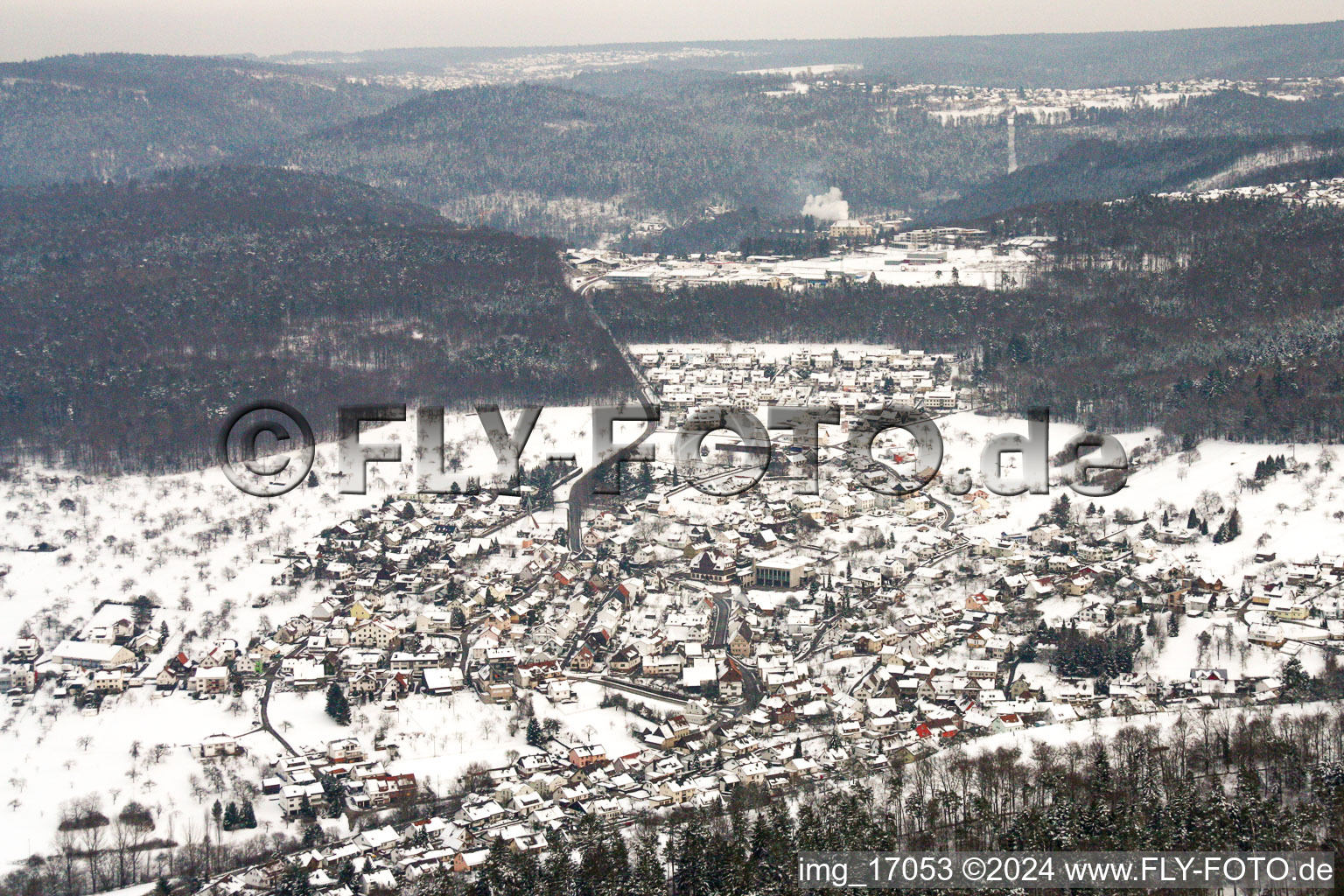 Wintry snowy Village - view on the edge of agricultural fields and farmland in Birkenfeld in the state Baden-Wurttemberg, Germany