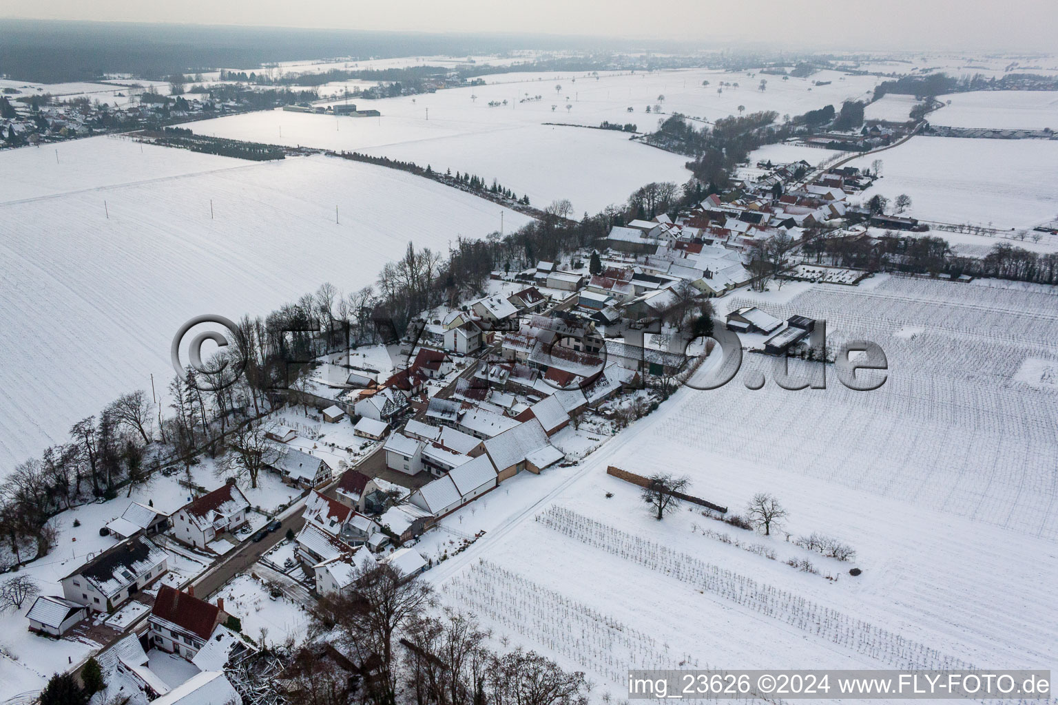 Wintry snowy Village - view on the edge of agricultural fields and farmland in Vollmersweiler in the state Rhineland-Palatinate, Germany