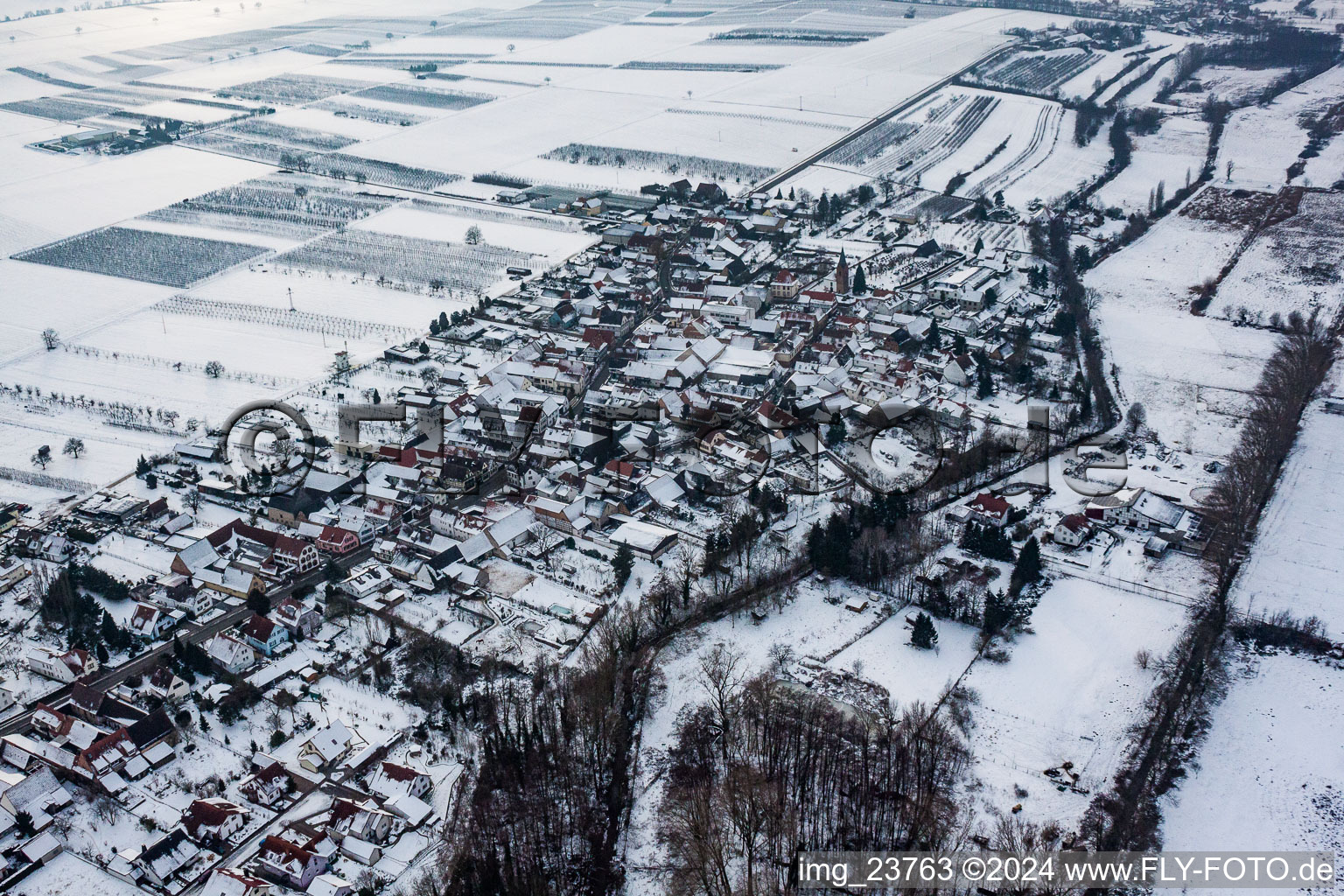 Aerial view of Wintry snowy Village - view on the edge of agricultural fields and farmland in Winden in the state Rhineland-Palatinate, Germany