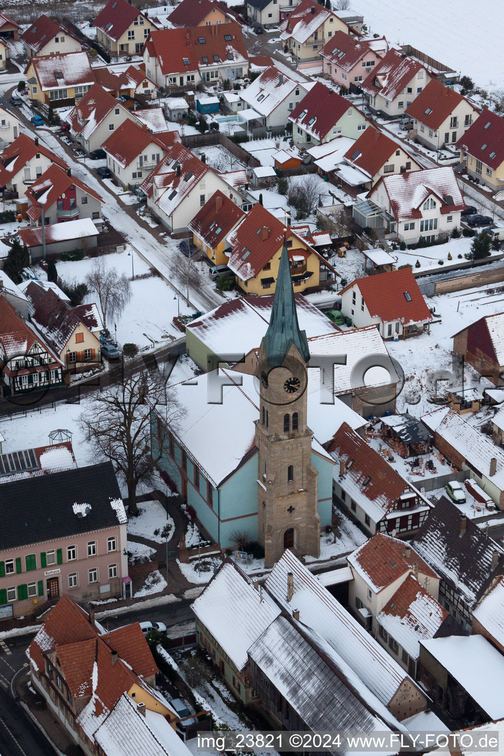 Winter snow-covered church buildings in the village centre in Erlenbach bei Kandel in the state Rhineland-Palatinate, Germany