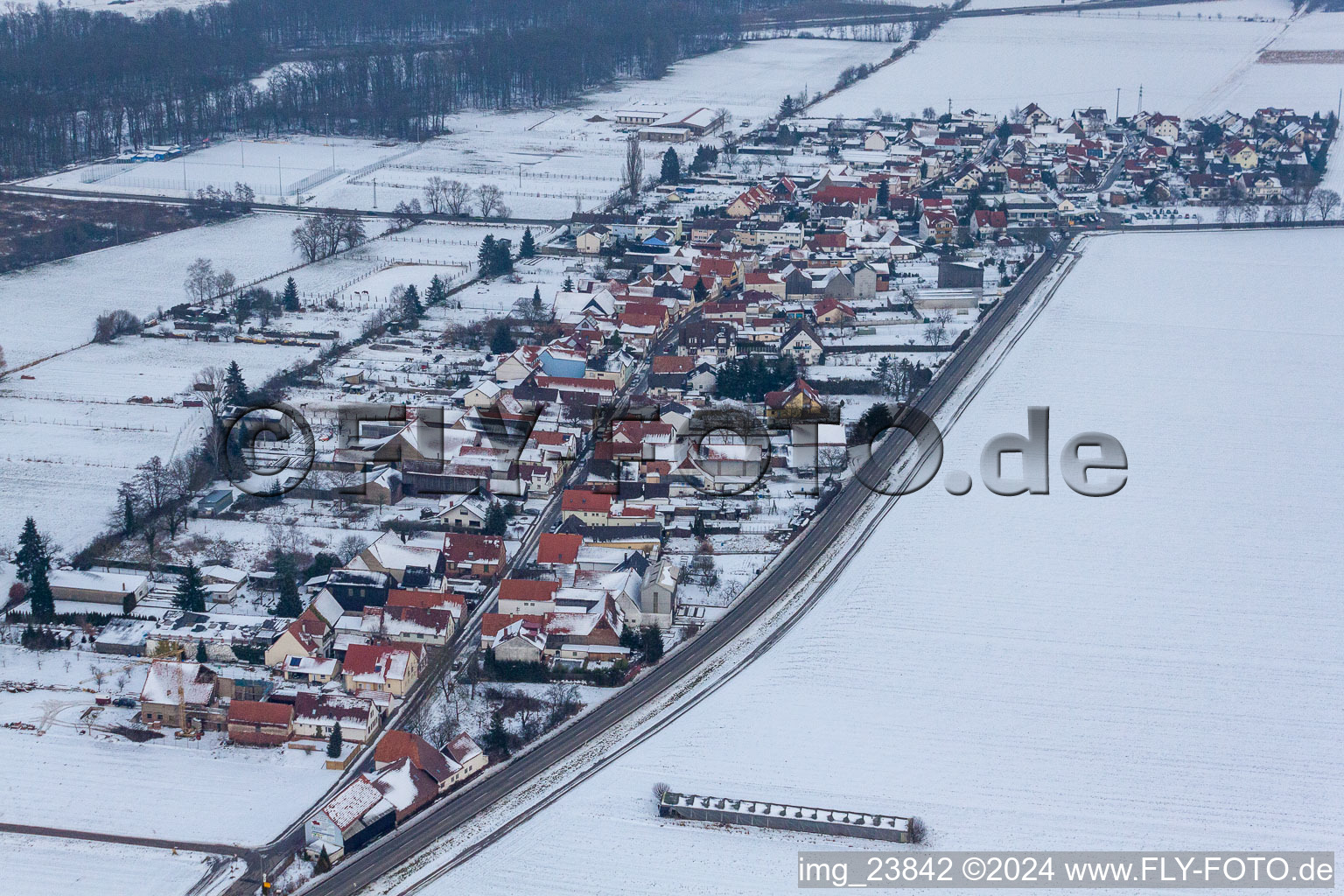 Wintry snowy Village - view on the edge of agricultural fields and farmland in the district Minderslachen in Kandel in the state Rhineland-Palatinate