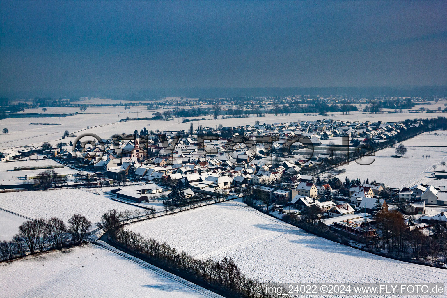 Wintry snowy Village - view on the edge of agricultural fields and farmland in Neupotz in the state Rhineland-Palatinate