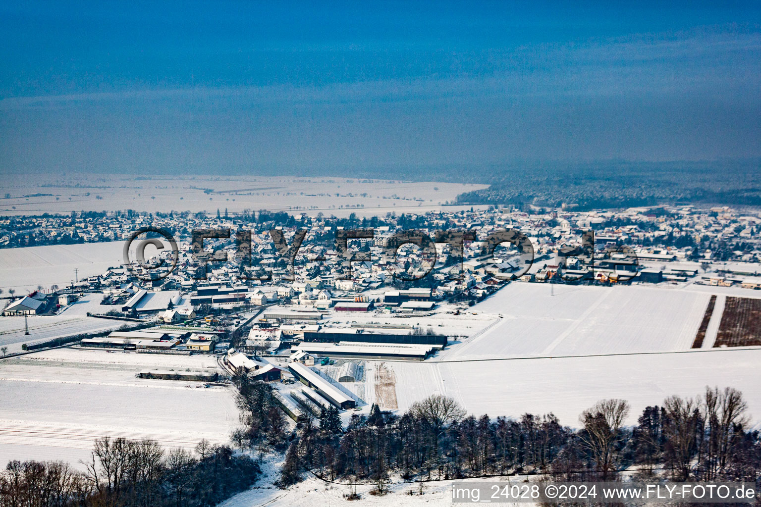 Wintry snowy Village - view on the edge of agricultural fields and farmland in Rheinzabern in the state Rhineland-Palatinate, Germany