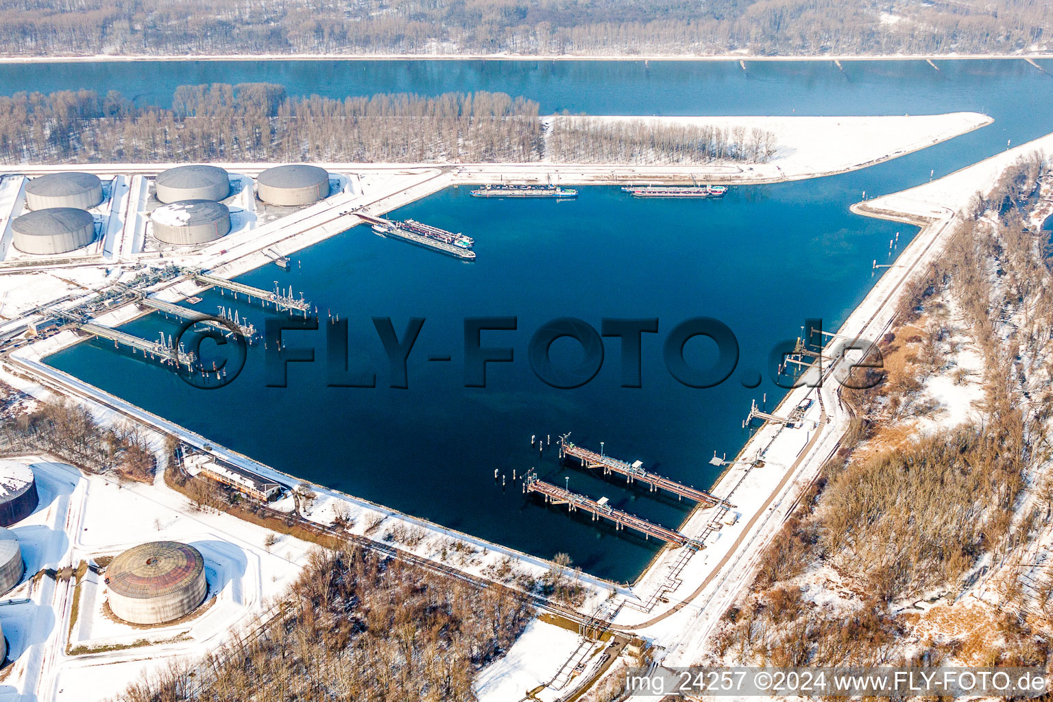 Wintry snowy Wharves and piers with ship loading terminals in the oil harbor in the district Knielingen in Karlsruhe in the state Baden-Wurttemberg, Germany