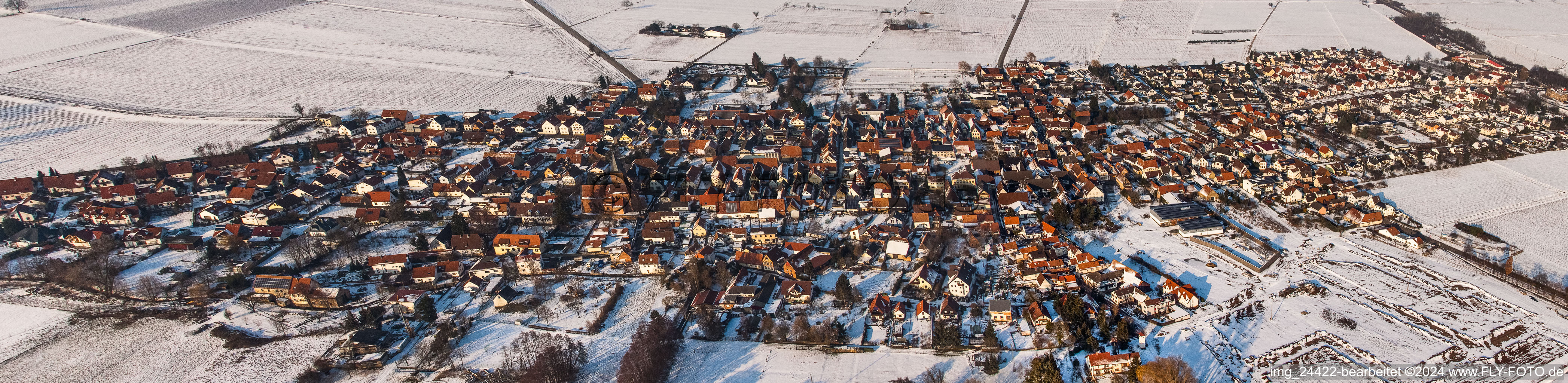 Panorama perspecitve of Wintry snowy Village - view on the edge of agricultural fields and farmland in Rohrbach in the state Rhineland-Palatinate, Germany