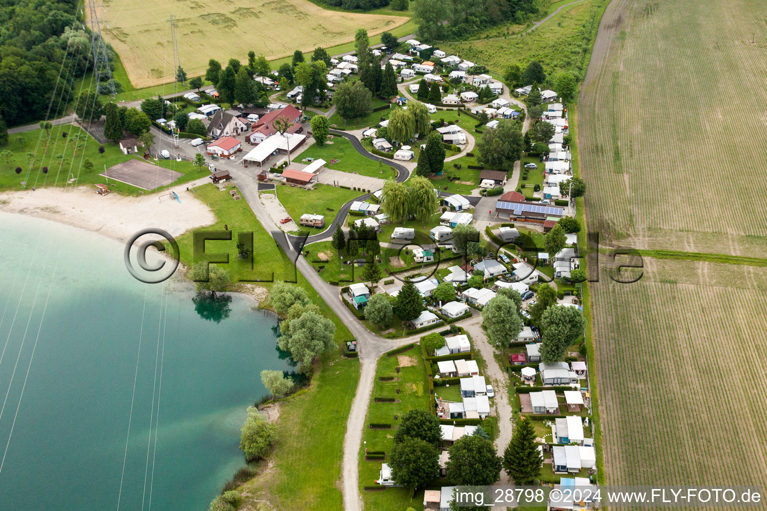 Camping with caravans and tents at the lake shore in Roeschwoog in Grand Est, France