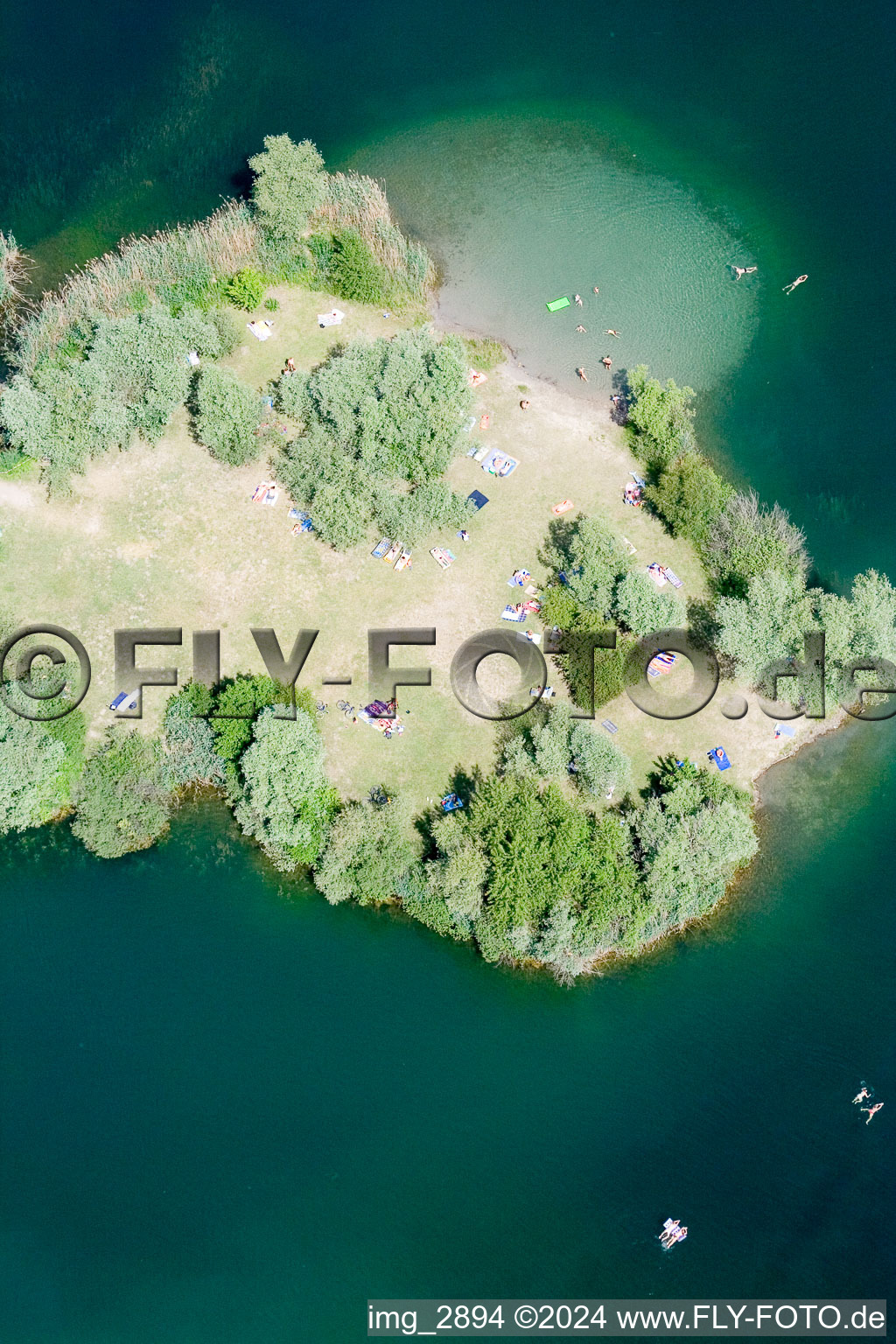 Bathers on the beach and the island of the lake Johanneswiese in Jockgrim in Jockgrim in the state Rhineland-Palatinate