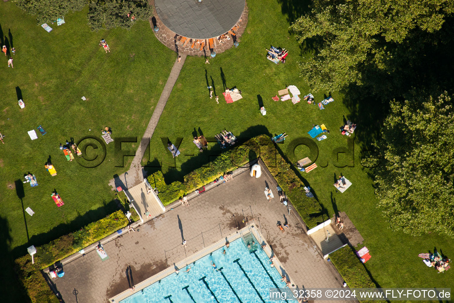 Bathers on the lawn by the pool of the swimming pool Rueppurr in Karlsruhe in the state Baden-Wurttemberg