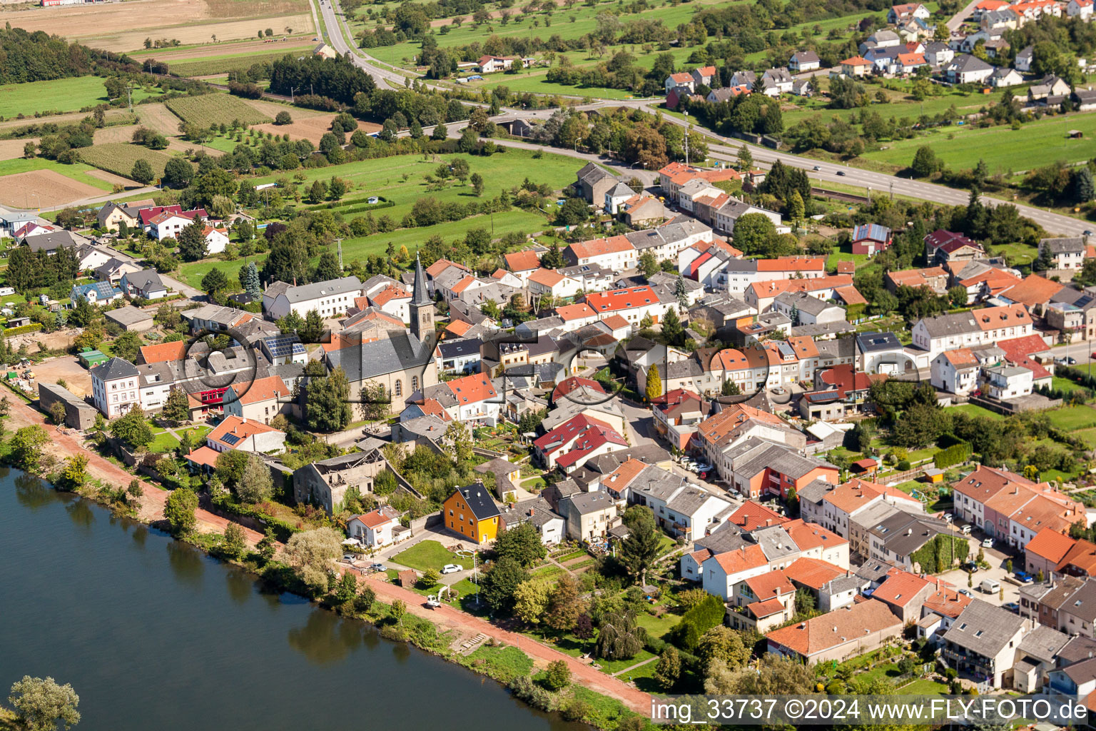 Town on the banks of the river of Mosel with St. Magaretha Kirche in the district Besch in Perl in the state Saarland, Germany