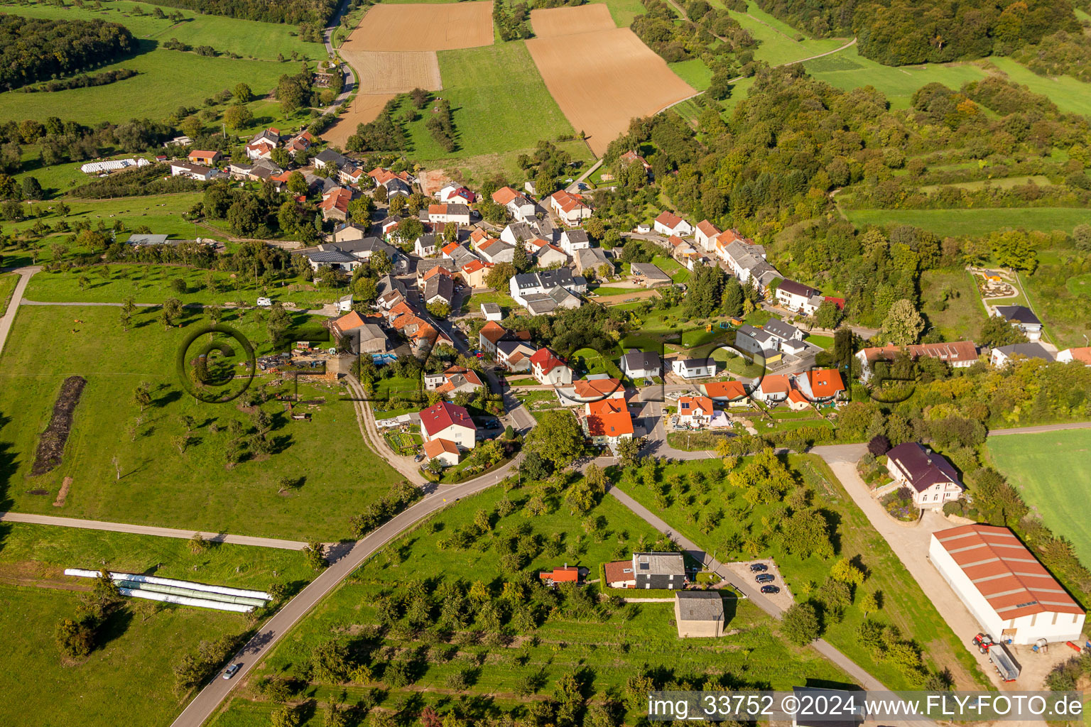 Village - view on the edge of agricultural fields and farmland in Wochern in the state Saarland, Germany