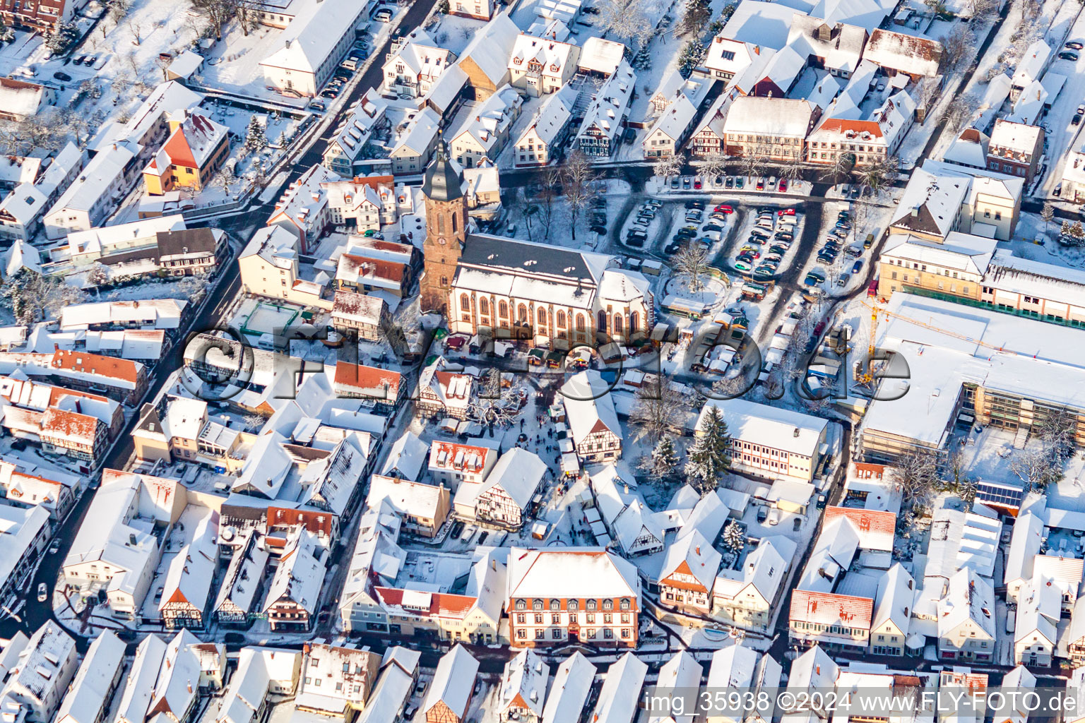 Oblique view of Christmas market at Plätzl and around St. George's Church in snow in Kandel in the state Rhineland-Palatinate, Germany