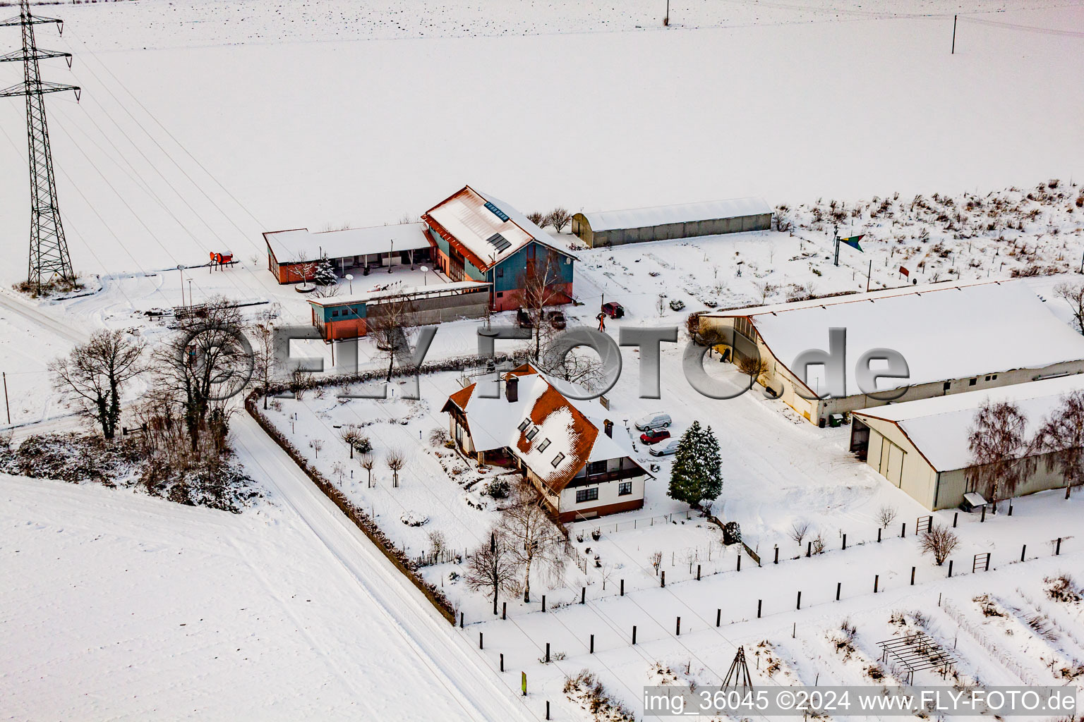 Aerial view of Schoßberghof in winter with snow in Minfeld in the state Rhineland-Palatinate, Germany