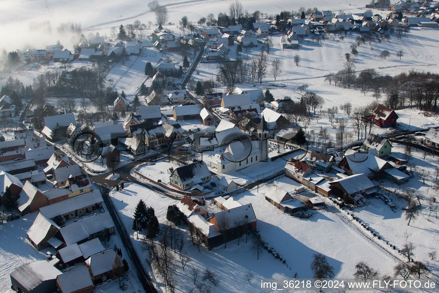 Aerial view of Wintry snowy Church building in the village of in Eberbach-Seltz in Grand Est, France