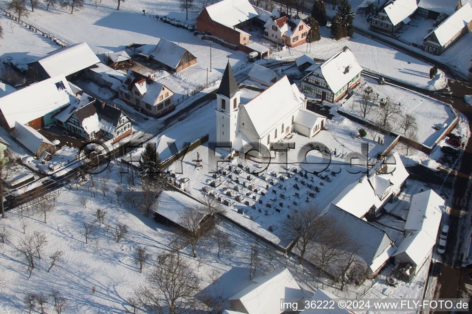 Wintry snowy Church building in the village of in Eberbach-Seltz in Grand Est, France from above