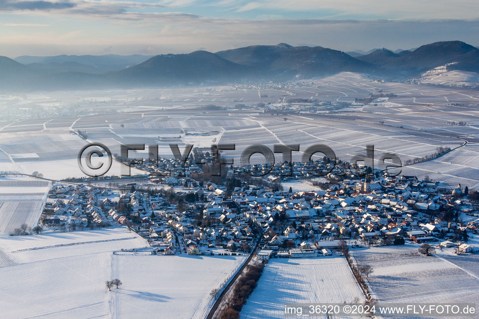 Aerial view of Wintry snowy Village - view on the edge of agricultural fields and farmland in the district Moerzheim in Landau in der Pfalz in the state Rhineland-Palatinate, Germany
