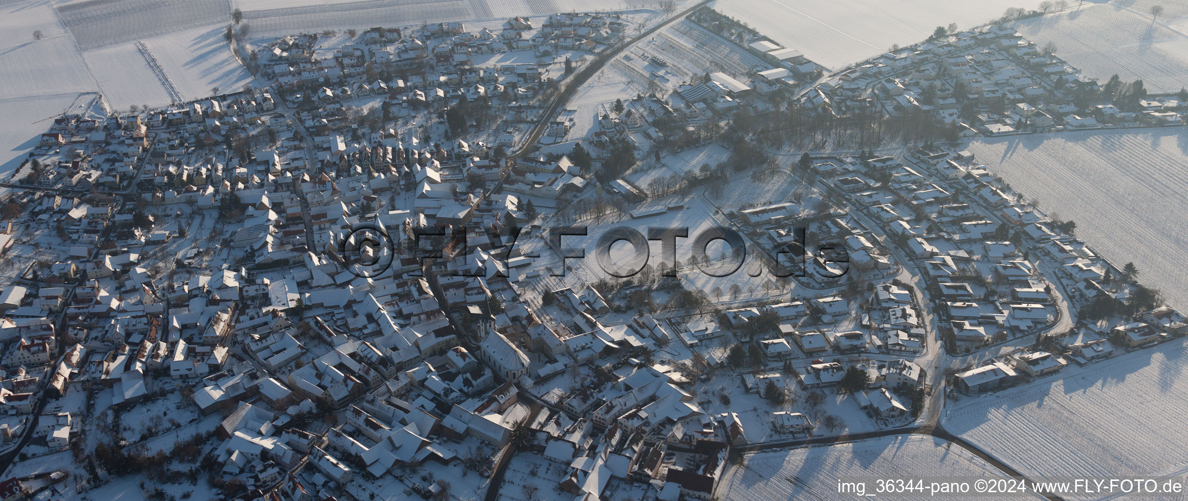 Oblique view of Wintry snowy Village - view on the edge of agricultural fields and farmland in the district Moerzheim in Landau in der Pfalz in the state Rhineland-Palatinate, Germany