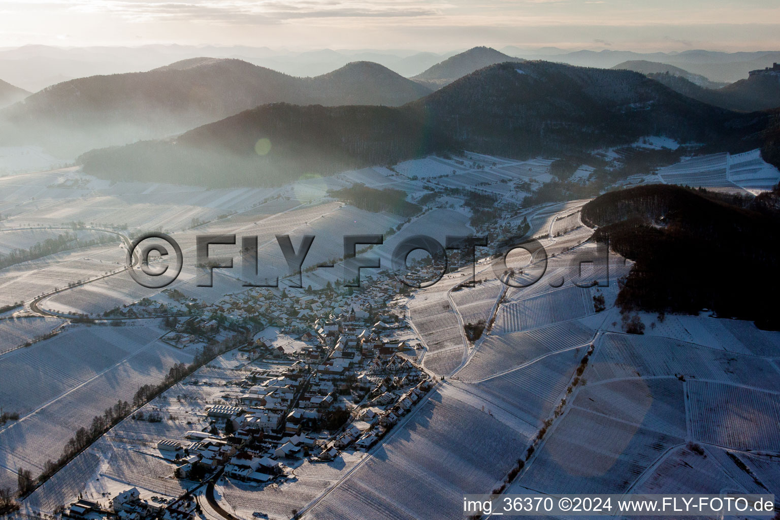 Aerial photograpy of Wintry snowy Village - view on the edge of snowed wine yards in Ranschbach in the state Rhineland-Palatinate, Germany