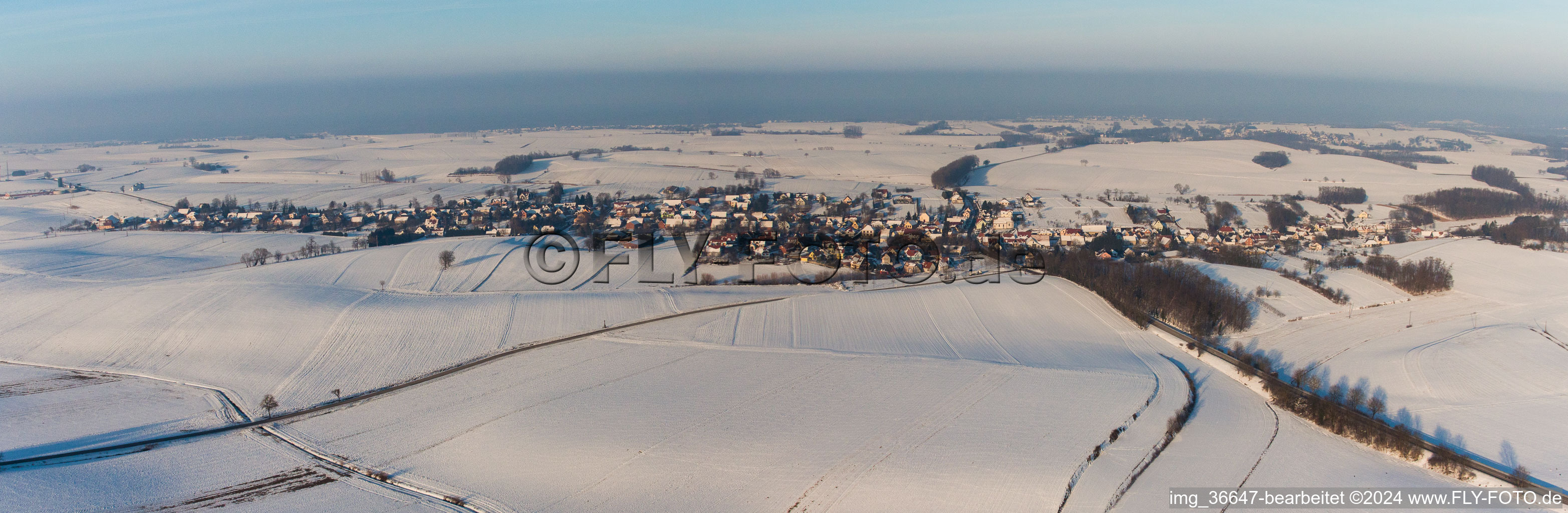 Wintry snowy Village - view on the edge of agricultural fields and farmland in Wintzenbach in Grand Est, France