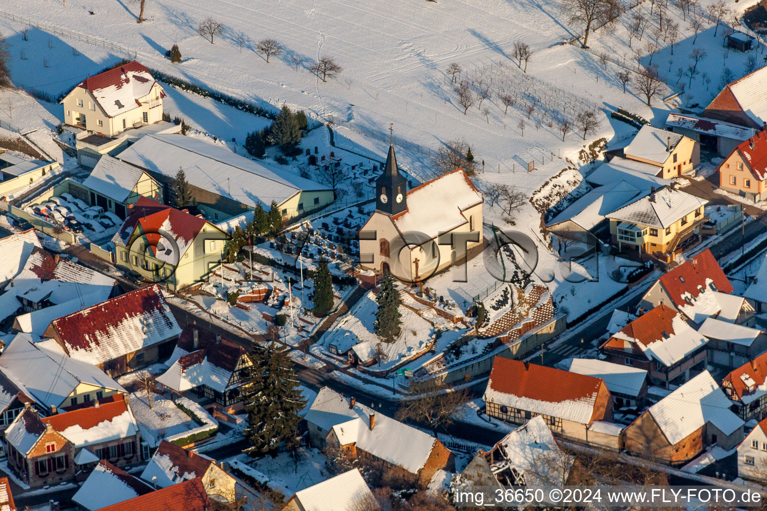 Aerial view of Wintry snowy Church building Eglise protestante de Wintzenbach in Wintzenbach in Grand Est, France