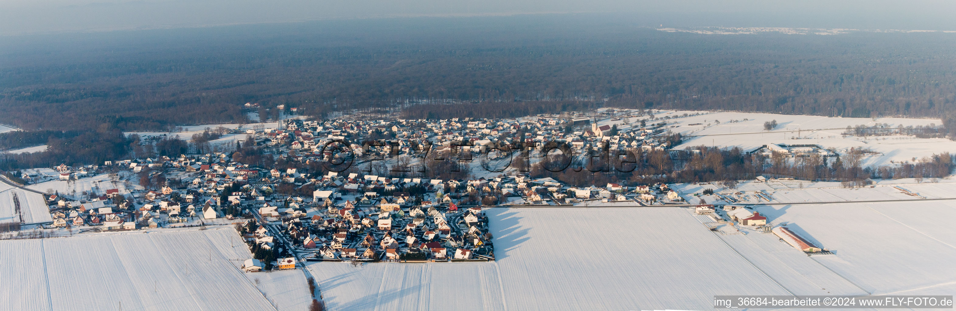Wintry snowy Village - view on the edge of agricultural fields and farmland in Scheibenhard in Grand Est, France