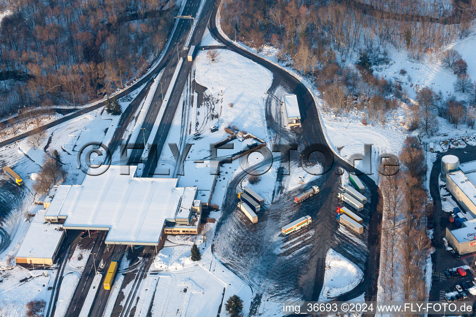 Wintry snowy Lorries and Truck storage areas and free-standing storage on former customs Lauterbourg now state-police department Bienwald in Scheibenhard in Grand Est, France