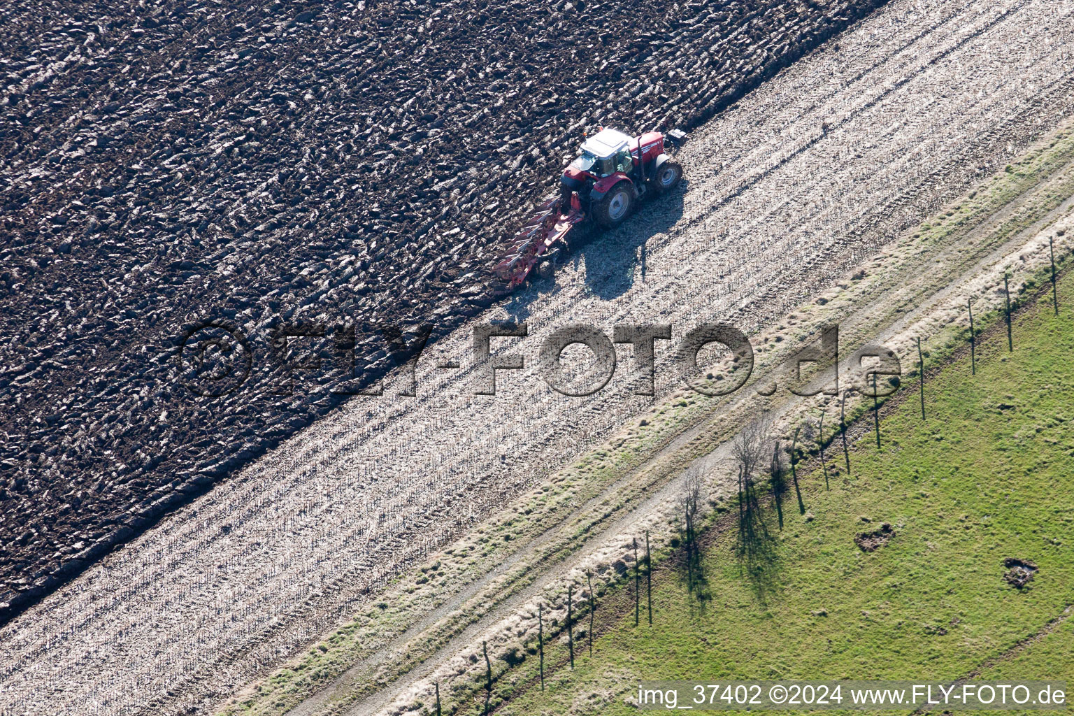 Plowing and shifting the earth by a tractor with plow on agricultural fields in Lampertsloch in Alsace-Champagne-Ardenne-Lorraine, France