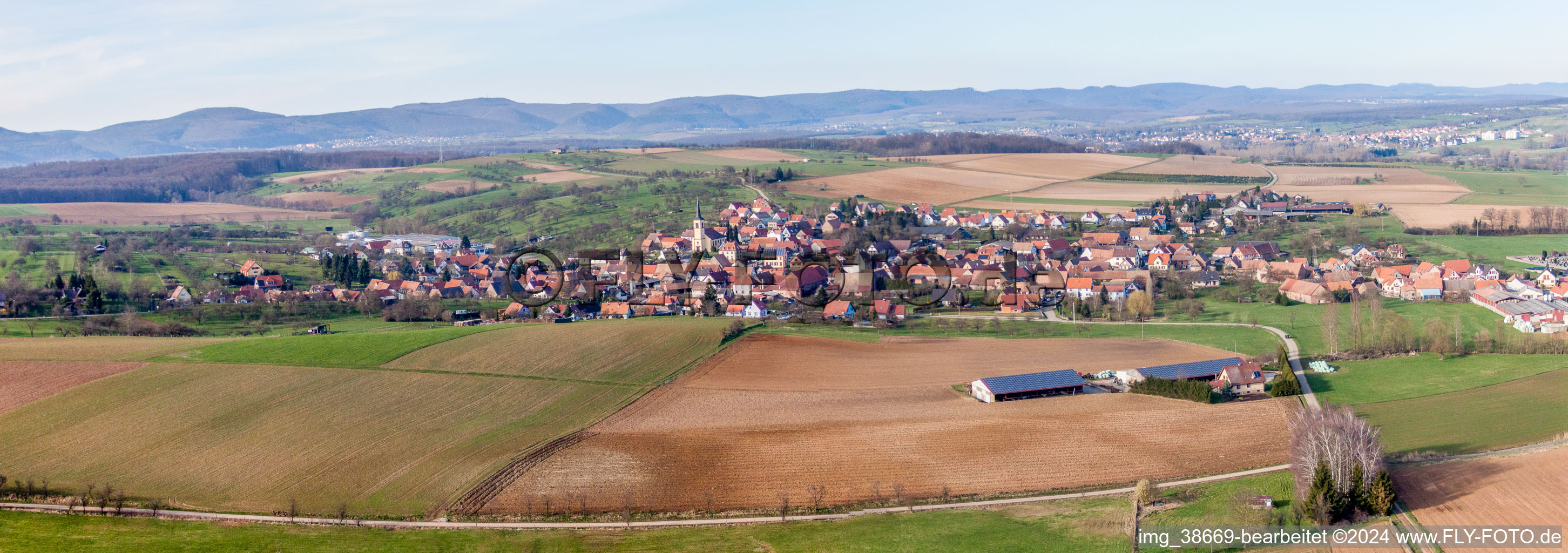Aerial view of Panoramic perspective Village - view on the edge of agricultural fields and farmland in Mietesheim in Grand Est, France