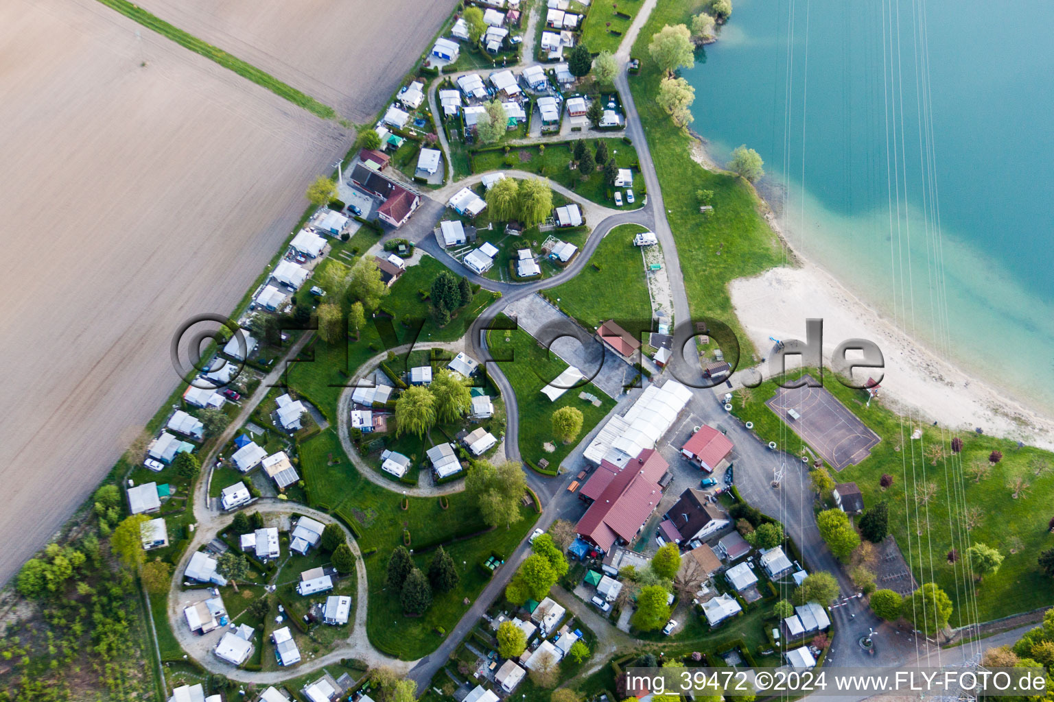 Aerial view of Camping with caravans and tents at the lake shore in Roeschwoog in Grand Est, France