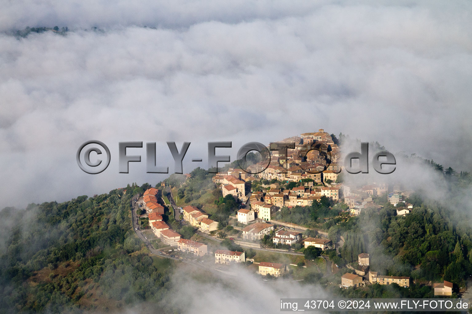 View of the town with high fog cloud layer over streets and houses of the residential areas in the district Civitella Marittima in Civitella Paganico in the state Grosseto, Italy