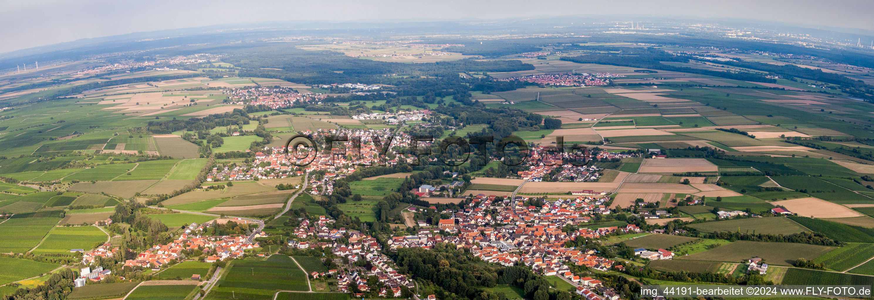 Panoramic perspective Village - view on the edge of agricultural fields and farmland in Billigheim-Ingenheim in the state Rhineland-Palatinate, Germany