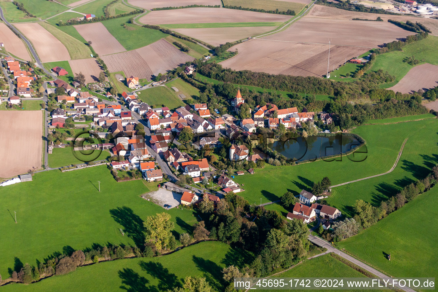 Village - view on the edge of agricultural fields and farmland in the district Schnodsenbach in Scheinfeld in the state Bavaria, Germany